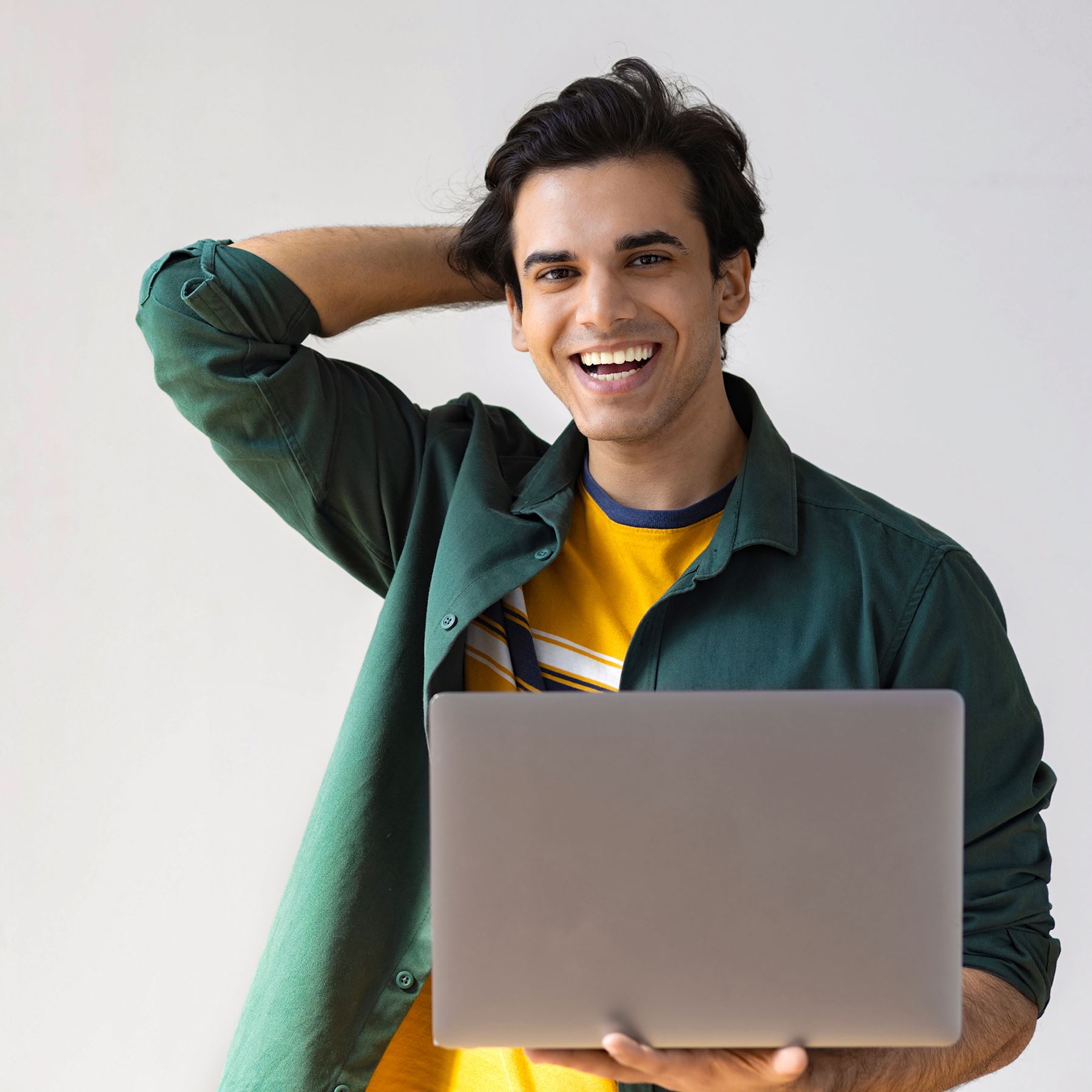 A man holding a laptop and smiling.